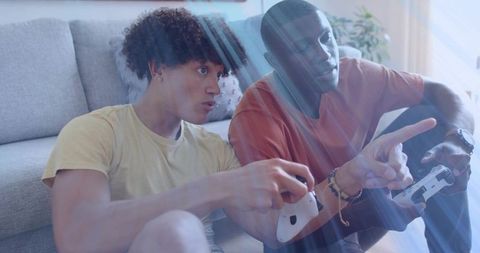 Friends playing console games on living room floor with wireless controllers and sunbeams
