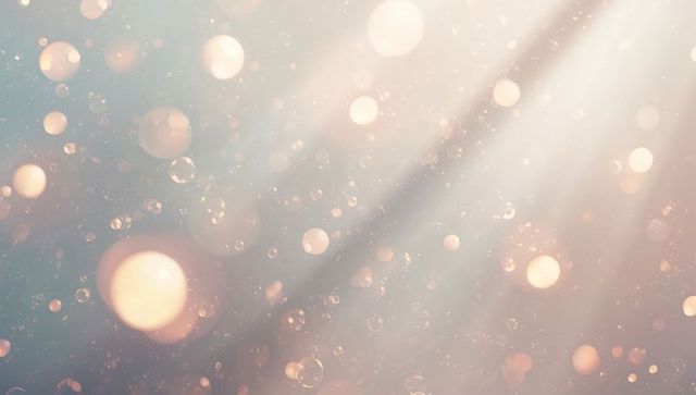 Glowing pastel bokeh with diagonal light rays and floating particles for dreamy background