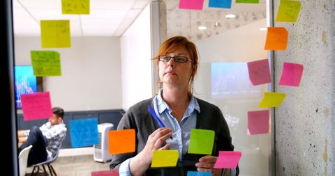 Focused Businesswoman Brainstorming with Sticky Notes in Office - Download Free Stock Images Pikwizard.com