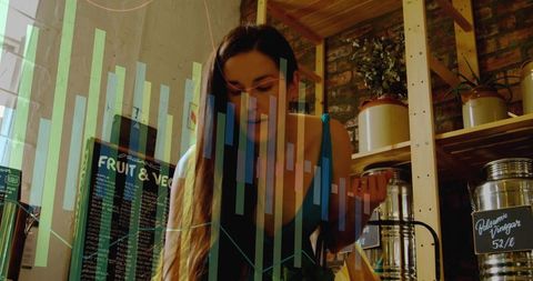 Young woman examining bulk jar in boutique zero-waste shop with digital sales charts overlay