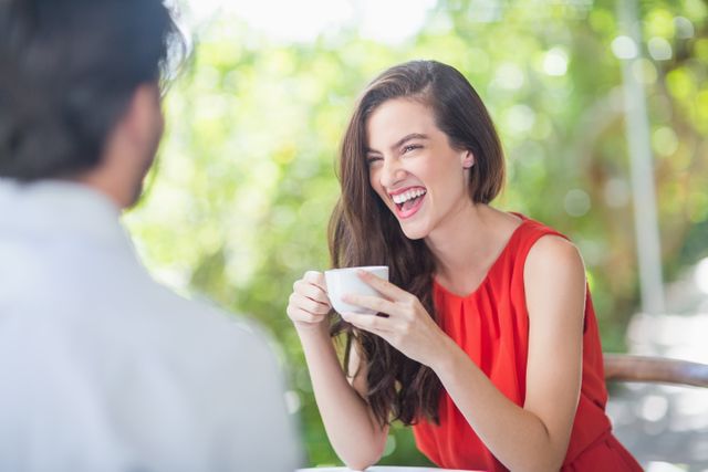 Beautiful woman laughing while having coffee in the restaurant