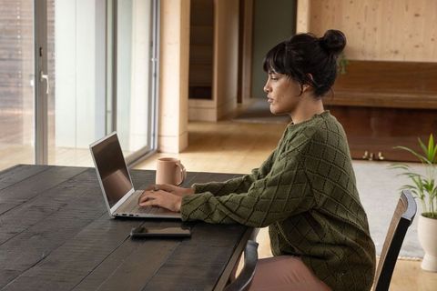 Asian Woman Working on Laptop in Cozy Minimalist Interior