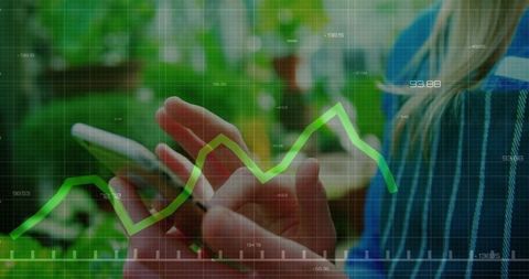 Woman scrolling smartphone with green financial chart overlay and indoor plants background