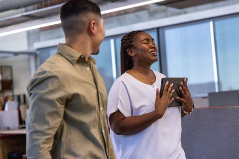 Emotional coworkers celebrating office achievement