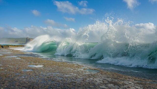 Dramatic ocean waves crashing against rugged shoreline
