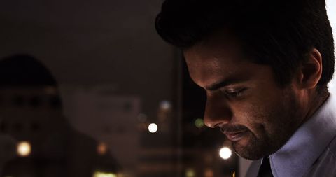 Focused Business Professional Analyzing Data on Tablet at Night