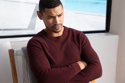 Contemplative Man Sitting Beside Pool in Sweater