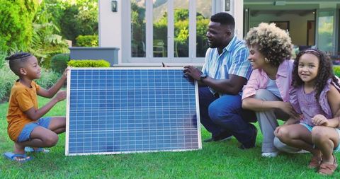 Family Exploring Renewable Energy with Solar Panel in Yard