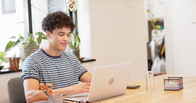 Young Man Working on Laptop at Contemporary Home Office - Download Free Stock Images Pikwizard.com