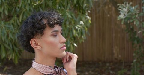 Young man posing serene outdoors with fashion scarf