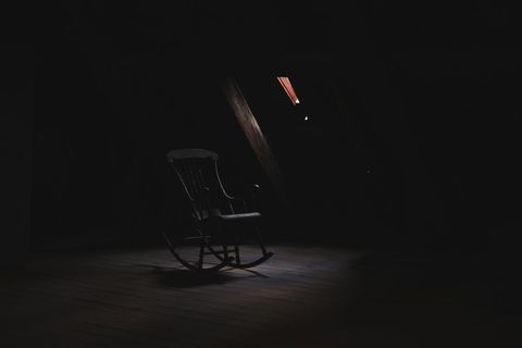 Lonely rocking chair in dimly lit attic