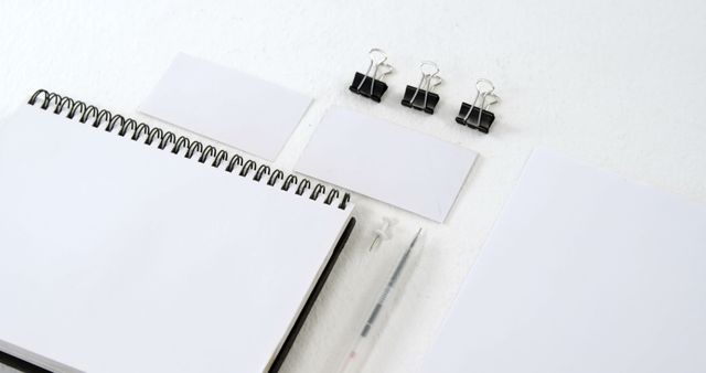 Blank business cards are displayed on a spiral notebook, with copy space. Ideal for a professional mockup, the setup allows for the addition of contact information or branding elements.