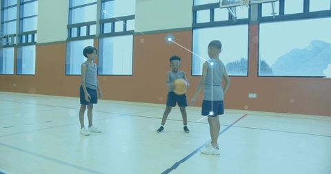 Youth basketball players practicing skills on indoor court