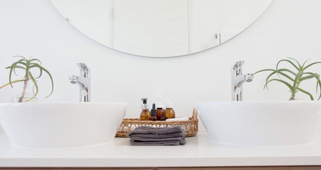 Clean, contemporary double vanity bathroom scene featuring two white sinks, a round mirror, and an arrangement of skincare products and potted plants. Ideal for use in home decor magazines, skincare product advertisements, interior design portfolios, and bathroom makeover articles.