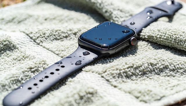 Glinting smartwatch with water droplets on towel highlighting waterproof sport-ready design