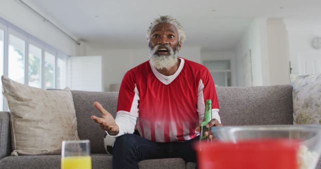 Elderly man excitedly watching sports game on TV at home - Download Free Stock Images Pikwizard.com