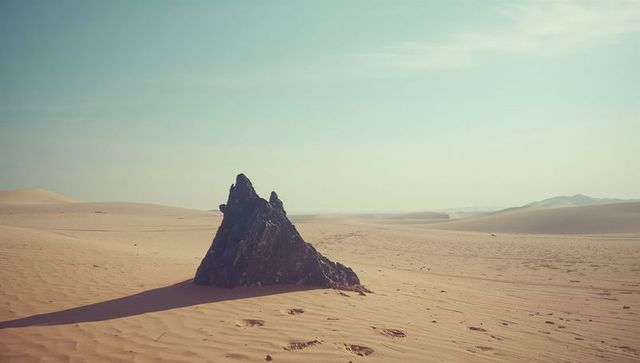 Solitary Rock Formation in Expansive Desert Landscape