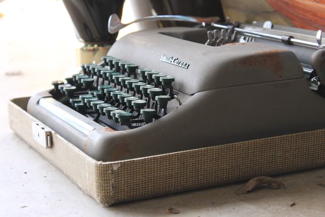 Close-up of a vintage Smith-Corona typewriter with visible signs of wear and rust. The image highlights the tactile and nostalgic feel of old-fashioned typing equipment making it ideal for blogs, articles, and advertising related to history, writing, vintage items, and retro decor.