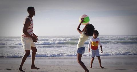 Joyful Family Playing Beach Volleyball by Ocean Waves