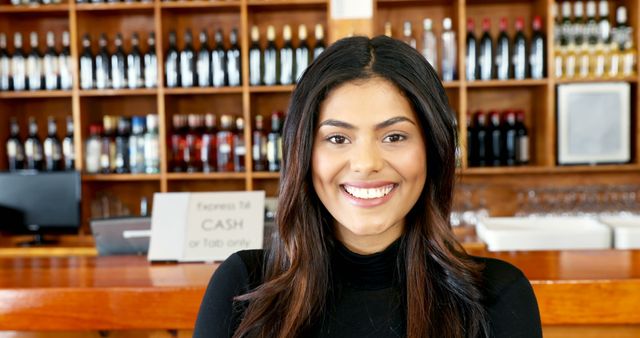Smiling Female Bartender in Front of Bar Shelves with Bottles - Download Free Stock Images Pikwizard.com