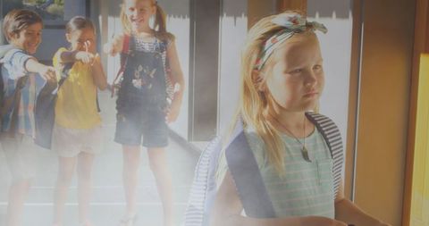 Upset child with mocking classmates in background