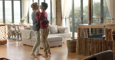 Couple Enjoying Playful Dance in Sunlit Living Room
