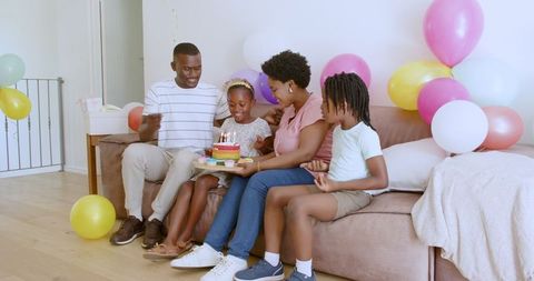 Family Celebrating Birthday with Cake and Balloons at Home