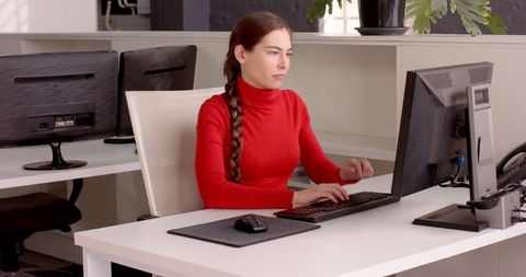 Focused Woman Typing on Keyboard at Modern Office Workspace