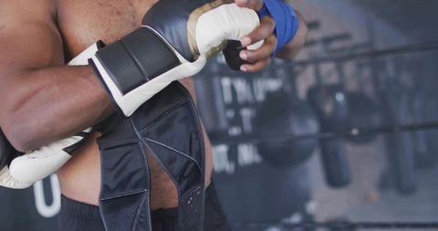 Boxer Securing Hand Wraps at Gym Representing Strength and Dedication