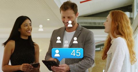 Coworkers working on tablets showing notification 45 for team growth in modern workspace
