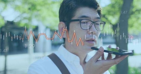 Businessman dictating on smartphone, finance chart overlay