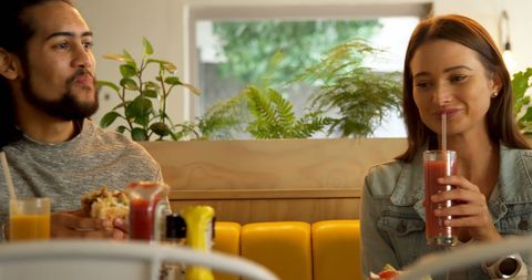 Young friends enjoying meal together at cozy diner