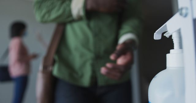 Close-up of Person Using Hand Sanitizer in Office Entrance - Download Free Stock Images Pikwizard.com