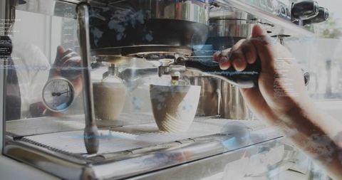 Barista pulling espresso shot on commercial machine, portafilter in hand, cups below