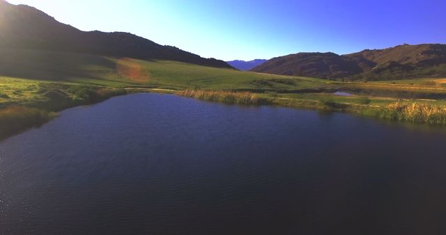 Aerial of lake and mountains on a sunny day 4k