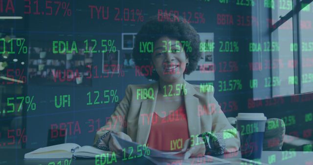 Image of financial data processing over african american businesswoman having a call in office. Global business, finance, computing and data processing concept digitally generated image.