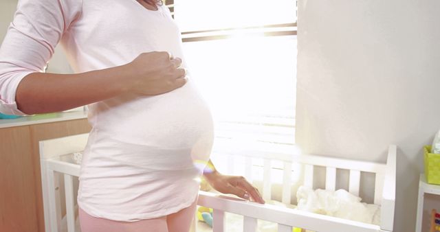 Pregnant Woman Standing by Crib in Sunlit Room - Download Free Stock Images Pikwizard.com