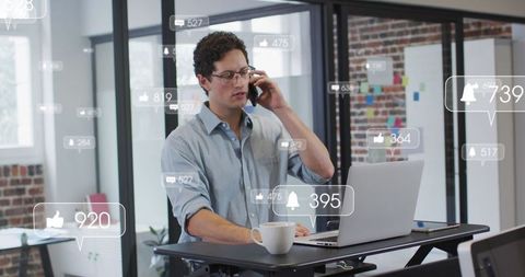 Professional using smartphone and laptop in modern office with digital overlays