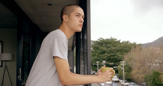 Young Man Sipping Coffee on Balcony - Download Free Stock Images Pikwizard.com