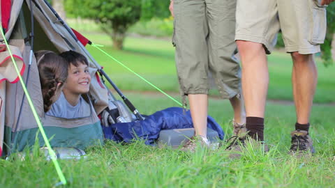 Smiling Children Playing in Tent with Parents at Park