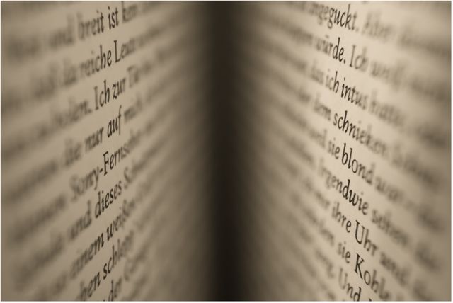 Abstract close-up of German text in book, blurred with sepia tone. Useful for themes in literature, reading, typography, and language learning material. Ideal for use in educational content, design projects, text graphics, and literary themed ads.
