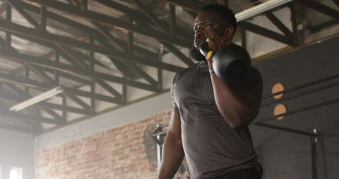 Determined male lifting kettlebell in urban industrial gym