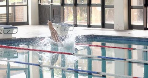 Swimmer Diving from Starting Block Creating Splash