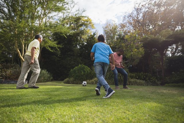 Multi-generation family playing soccer together at park