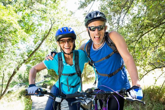 Senior couple standing with their bikes in a forest