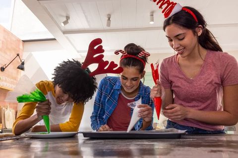 Diverse Friends Joyfully Decorating Festive Holiday Cookies Together