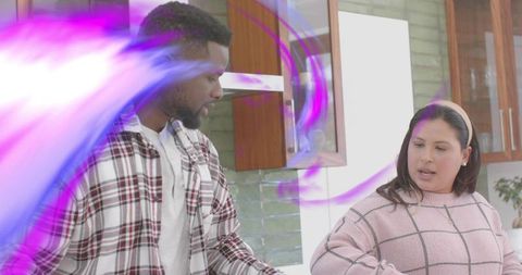 Couple talking and cooking in modern kitchen with purple light swirl