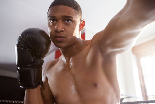 Determined man practicing boxing at fitness studio