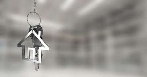 Silver house-shaped keychain with keys in modern office