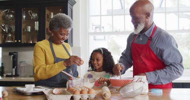 This image depicts an elderly couple cooking with their granddaughter in a bright kitchen. It illustrates family bonding, togetherness, and the passing down of cooking traditions. Perfect for use in family lifestyle articles, parenting blogs, or advertising related to home, family, and food.